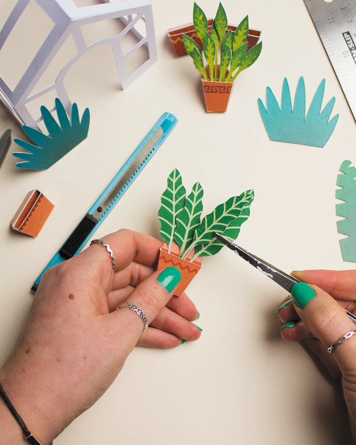 Project Calm: Clare placing fronds into a plant pot, made of paper