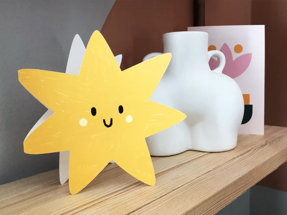 Star shaped greetings card, propped up on a shelf.