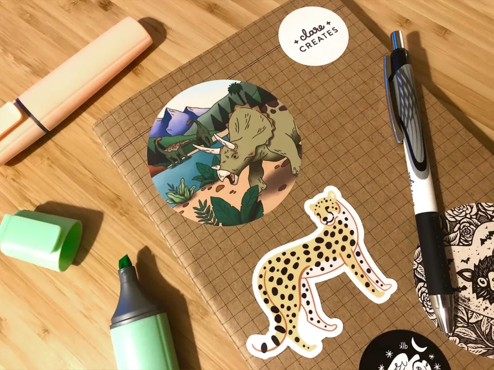 Extinction scene sticker featuring a triceratops, stuck on a notebook