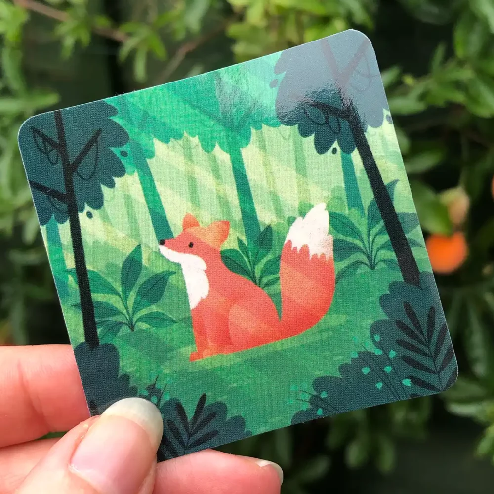 Illustrated sticker featuring a fox in a forest clearing