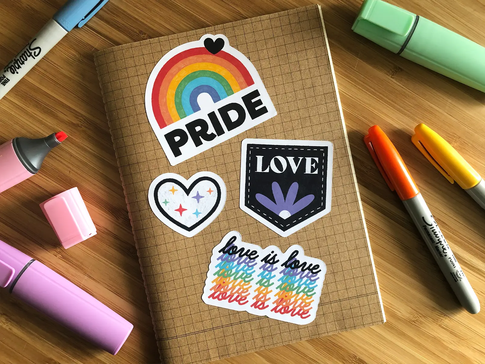 4 pride stickers on a notebook